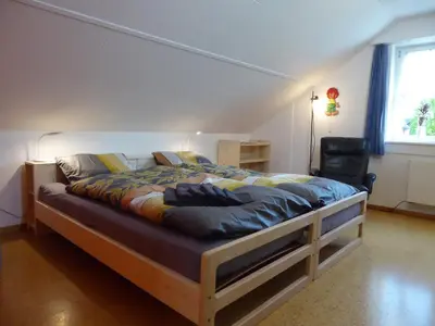 a large bed in a room with a window at 22 – Zimmer & Zmorge in Kreuzlingen