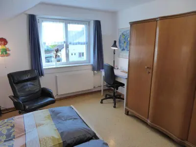 a bedroom with a bed and a desk and a chair at 22 – Zimmer & Zmorge in Kreuzlingen