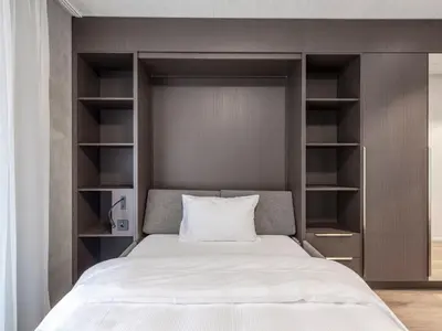 a bedroom with a large bed with open shelves at MOOI Apartments St.Gallen in St. Gallen