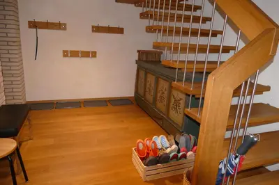 a room with a staircase with shoes under it at Family Landhaus Birwinken in Berg