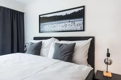 a bedroom with a white bed with a picture on the wall at SOHO 12 !Gratis Parken, Free Parking! in Kreuzlingen