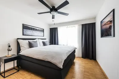 a bedroom with a large bed with a ceiling fan at SOHO 12 !Gratis Parken, Free Parking! in Kreuzlingen