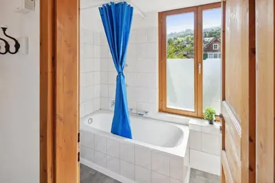 a bath tub in a bathroom with a window at FENUS Apartment mit traumhaftem Bergblick SGT02 in Grabs