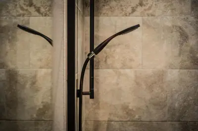 a glass shower door with two handles in a bathroom at Business Appartement 3 am Bodensee in Romanshorn