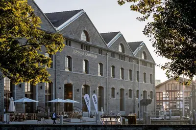 a large brick building with umbrellas in front of it at Business Appartement 3 am Bodensee in Romanshorn