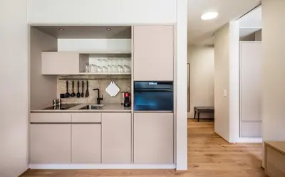 a kitchen with white cabinets and a sink at Business Appartement 2 am Bodensee in Romanshorn