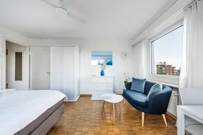 a bedroom with a bed and a chair and a window at SOHO 6 !Gratis Parken, Free Parking! in Kreuzlingen