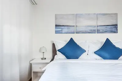 a bedroom with a white bed with blue pillows at SOHO 6 !Gratis Parken, Free Parking! in Kreuzlingen