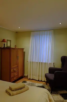 a bedroom with a bed and a chair and a window at Ferienwohnung im Grünen in Altstätten