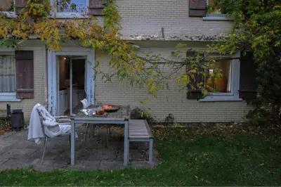 a table and a chair in front of a house at Ferienwohnung im Grünen in Altstätten