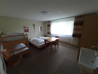 a room with a bedroom with a bed and a table at Haus St.Michael in Dozwil
