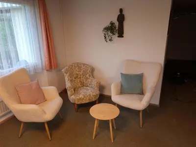 a living room with two chairs and a table at Haus St.Michael in Dozwil