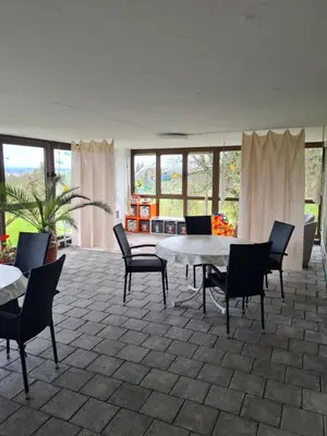 a living room with a table and chairs at Haus St.Michael in Dozwil