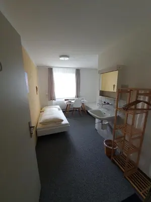 a room with a bed and a desk and a sink at Haus St.Michael in Dozwil