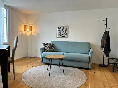 a living room with a blue couch and a table at Klara 1031 - Olma, Spital, Uni St- Gallen in St. Gallen