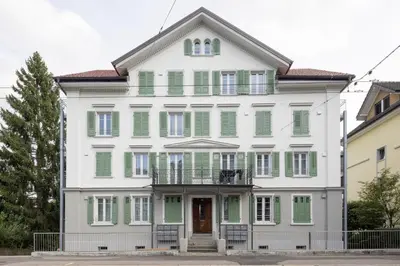 a large white house with green shutters at Klara 1031 - Olma, Spital, Uni St- Gallen in St. Gallen