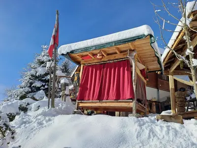 a living room with a couch and a television at IB Säntis Chalet Chnorz Rooms in Nesslau