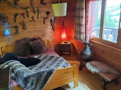 a bedroom with a bed in a log cabin at IB Säntis Chalet Chnorz Apartment in Nesslau