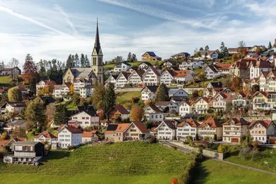 a town on a hill with houses and a church at Dorfhus Gupf in Rehetobel