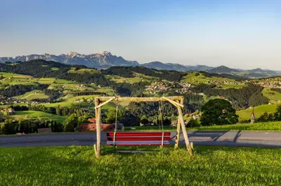 a bench sitting on the side of a road at Dorfhus Gupf in Rehetobel