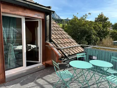 a patio with two tables and chairs on a balcony at Dachwohnung Zentrum Unterwasser in Unterwasser