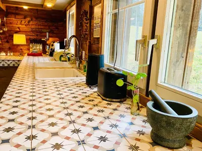 a kitchen with a counter with a tile floor at Birkenhof, Haus Märli in Herisau