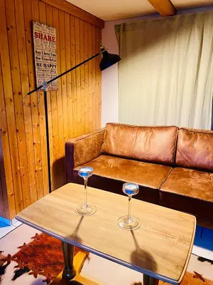 a living room with a couch and two wine glasses on a table at Birkenhof, Haus Schwänli in Herisau