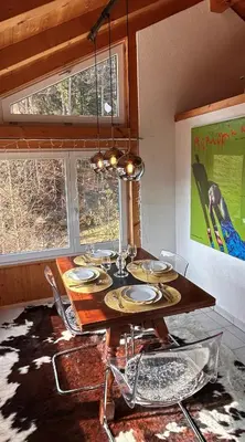 a dining room table with chairs and a chandelier at Wunderschöne Maisonette-Ferienwohnung in stattlichem Toggenburgerhaus in Sankt Peterzell
