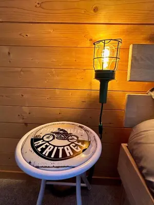 a table with a light on top of it next to a wall at Wunderschöne Maisonette-Ferienwohnung in stattlichem Toggenburgerhaus in Sankt Peterzell
