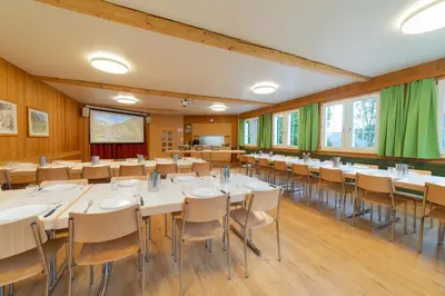 a conference room with tables and chairs in it at Ferienheim Bodenweidli in Wildhaus