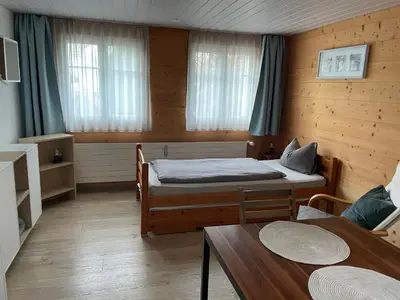 a small room with two beds and a table at Bijou 1 Hübsche 1 Zimmer Wohnung in Herisau