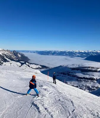 two people are skiing down a snow covered slope at Studio Bijou in Unterwasser