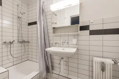 a white bathroom with a sink and a shower at SOHO 3B !Gratis Parken, Free Parking! in Kreuzlingen