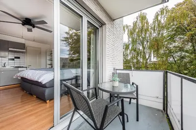 a room with a balcony with a bed and a table at SOHO 3B !Gratis Parken, Free Parking! in Kreuzlingen