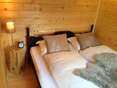 a bedroom with a bed in a log cabin at Villa Donkey Chalet in Degersheim