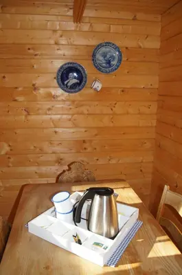 a tea kettle on a tray on a wooden table at Villa Donkey Chalet in Degersheim