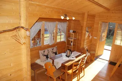 a dining room with a table and chairs in a cabin at Villa Donkey Chalet in Degersheim