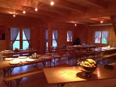 a large room with tables and a bowl of bananas at Villa Donkey Chalet in Degersheim