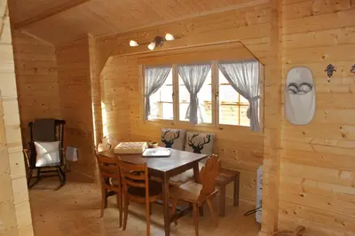 a dining room in a log cabin with a table and chairs at Villa Donkey Chalet in Degersheim
