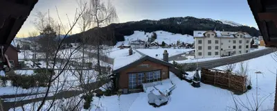 a small house in the snow with a mountain at Chalet Müsli in Wildhaus