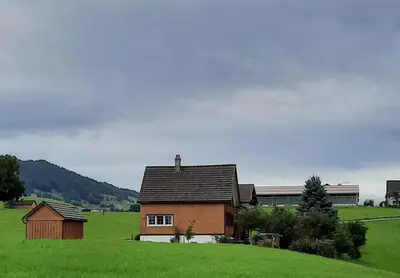 a house in a field with a green field at Ferienhaus Rütiweid in Appenzell