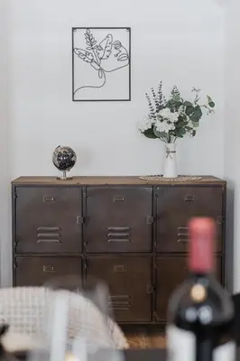 a wooden cabinet with a vase of flowers on top of it at Dein Zuhause in Herisau in Herisau