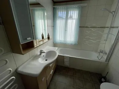 a bathroom with a sink and a tub and a toilet at Stockberghüsli in Nesslau