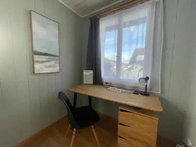 a desk and a chair in a room with a window at Stockberghüsli in Nesslau