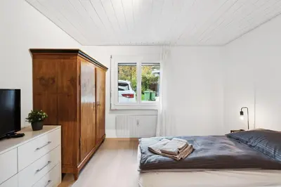 a bedroom with a bed and a dresser and a window at Sonniges Apartment mit traumhaftem Bergblick in Buchs