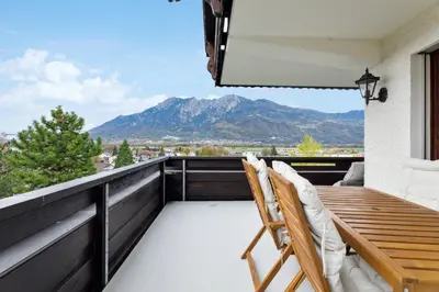 a balcony with two chairs and a view of a mountain at Sonniges Apartment mit traumhaftem Bergblick in Buchs