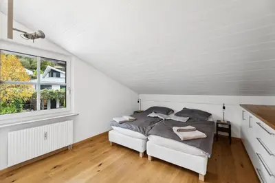 a white bedroom with a bed and a window at Sonniges Apartment mit traumhaftem Bergblick in Buchs