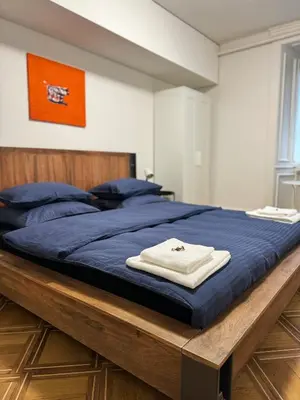 a large bed with blue sheets and blue pillows at tas24ch Travel and Sleep 24 in St. Gallen