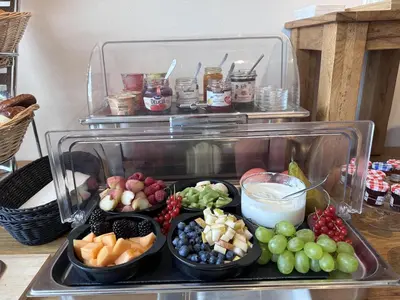 a tray of different types of fruit in bowls at Hotel Säntis Teufen in Teufen