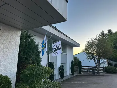 a building with flags on the side of it at Hotel Säntis Teufen in Teufen